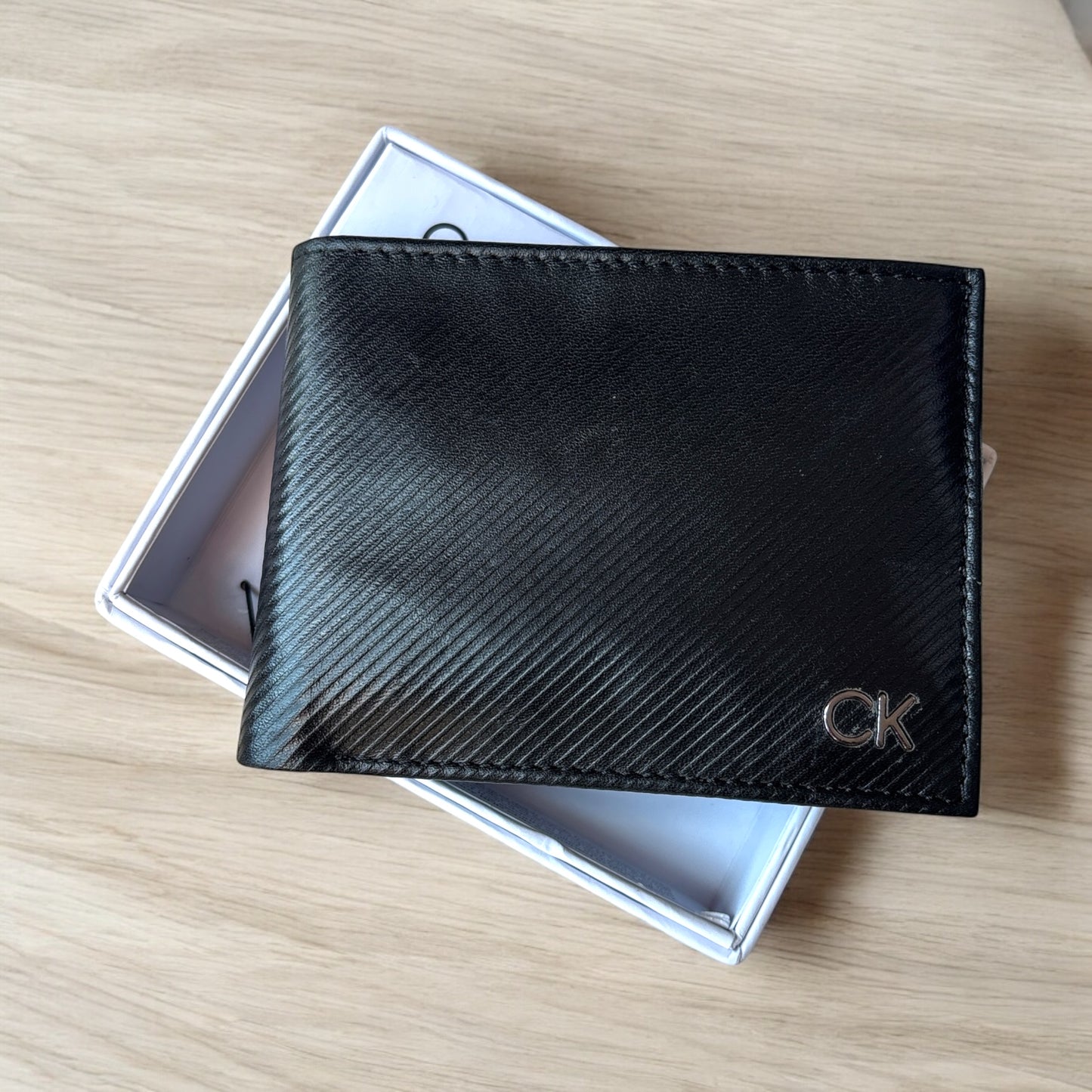 Cartera Calvin K negra con placa CK plateada