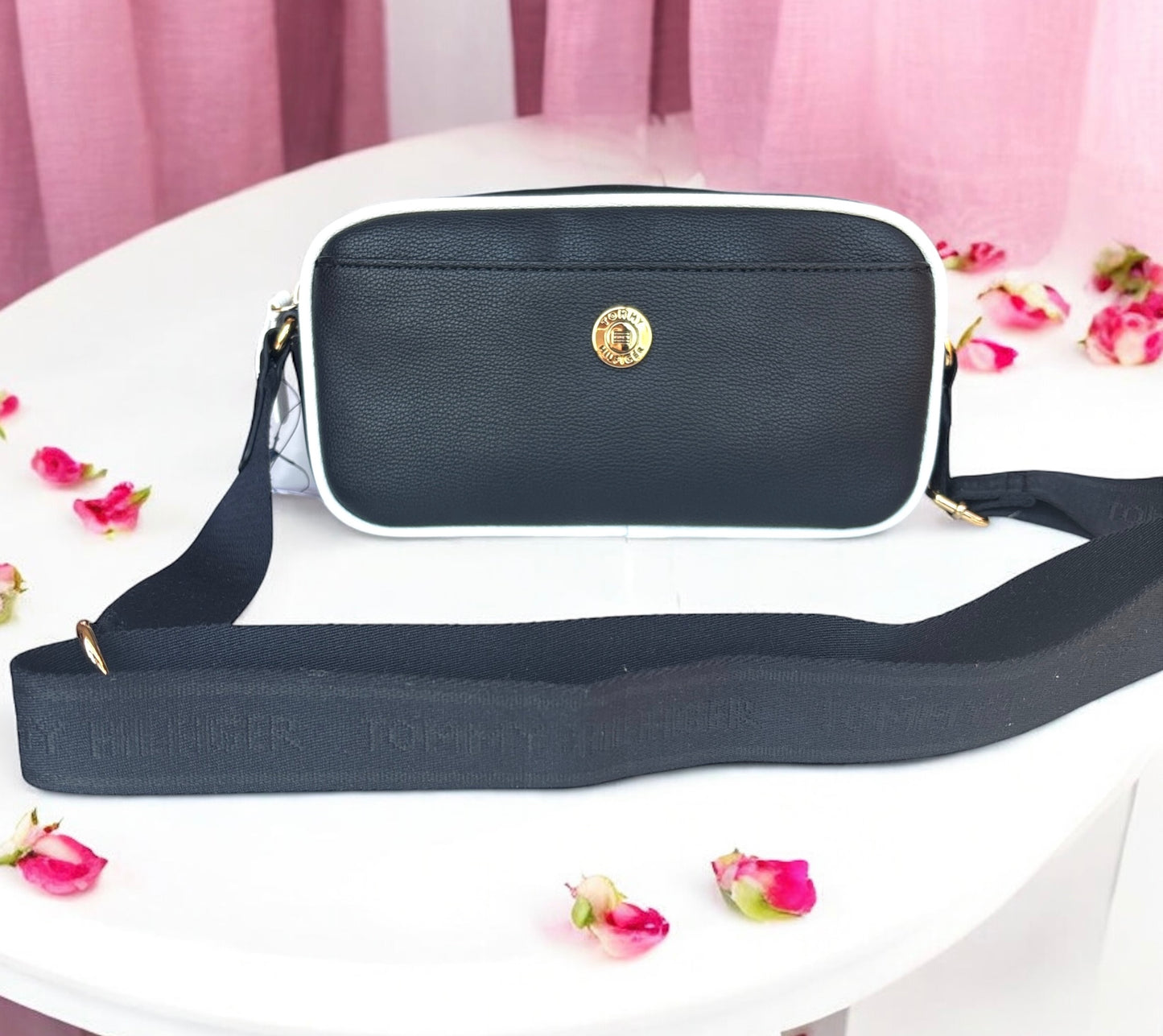 Crossbody Tommy H negra con contorno blanco y placa dorada redonda