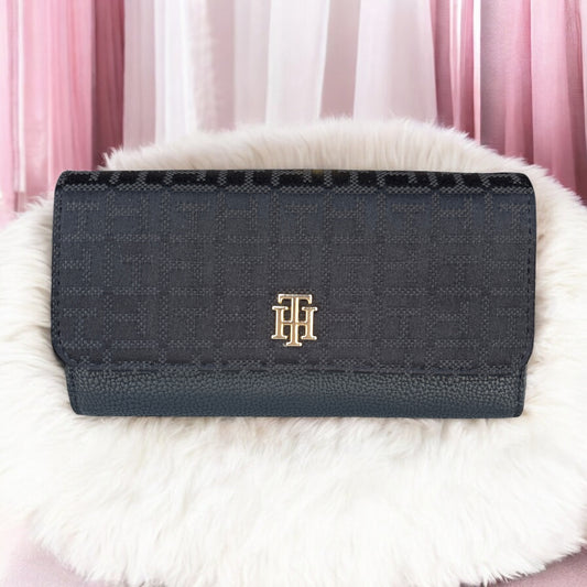Cartera Tommy H negra con monogram y placa dorada TH