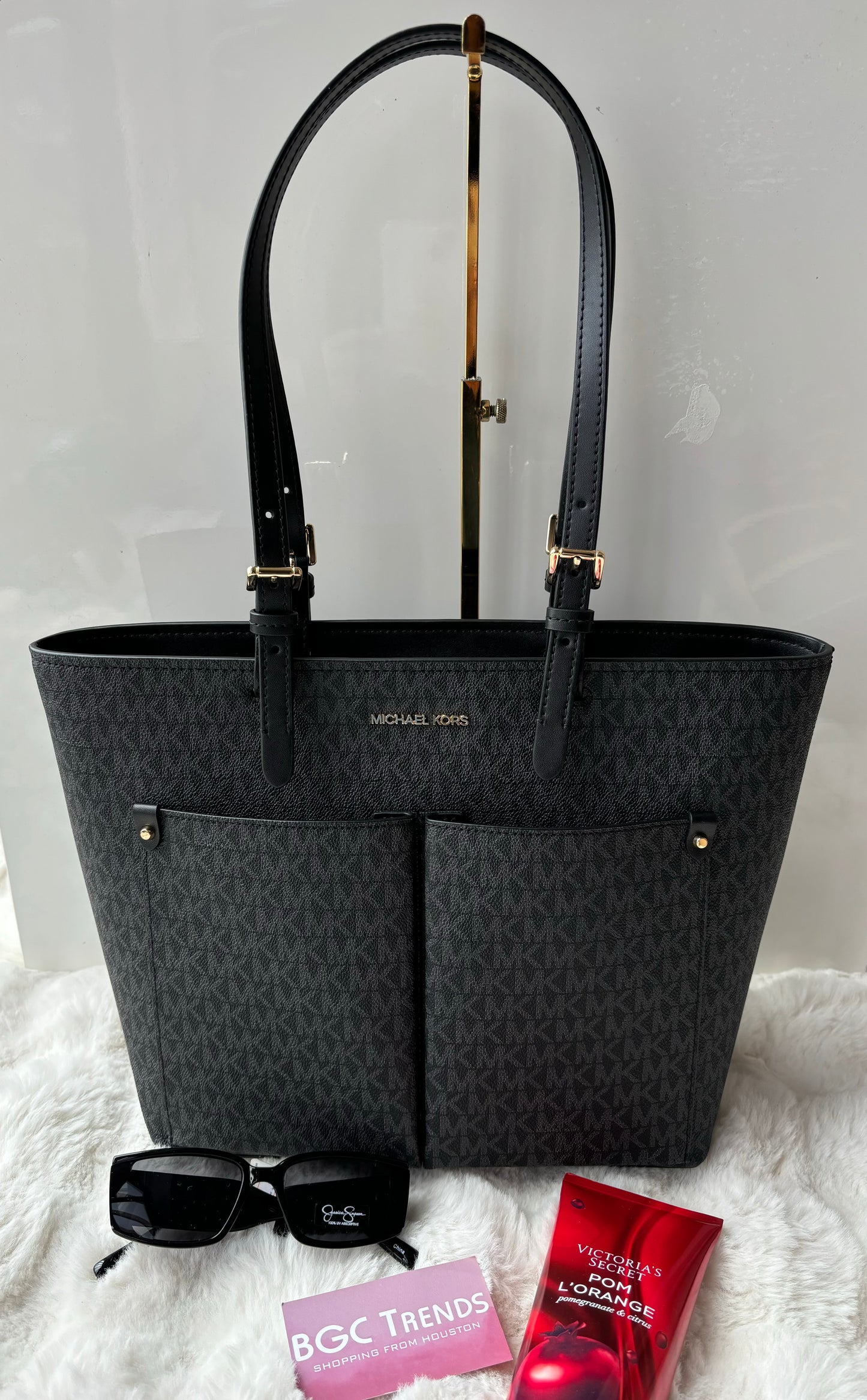 Tote Michael k negra con monogram y bolsas en frente