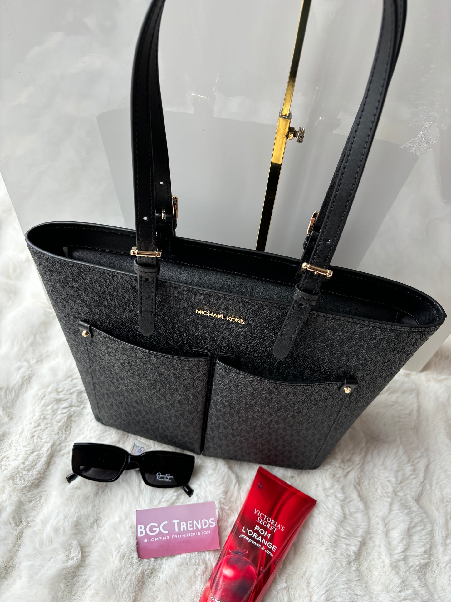 Tote Michael k negra con monogram y bolsas en frente