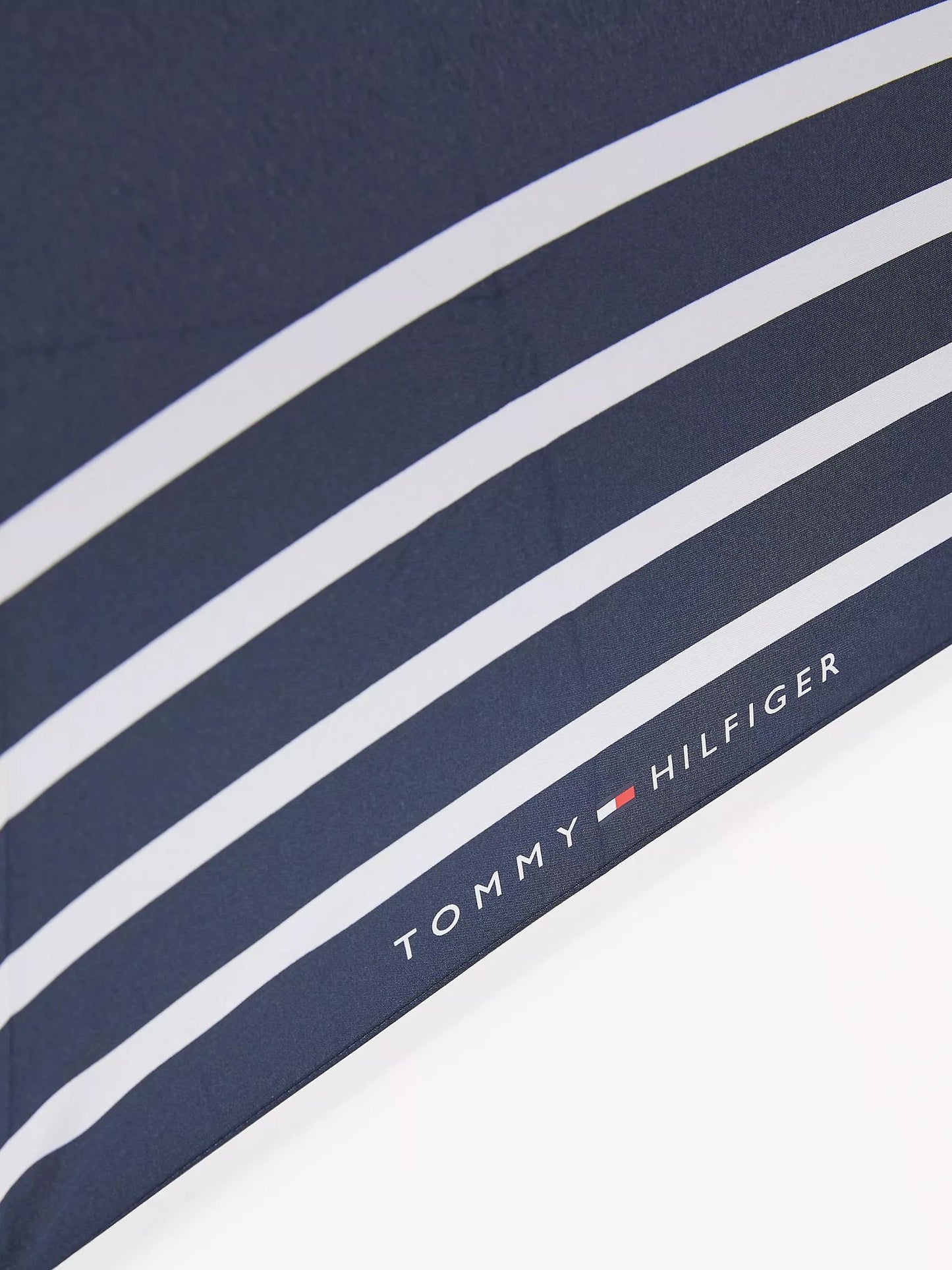 Sombrilla Tommy H azul marino con rayas blancas, mango negro y botones de abrir/cerrar