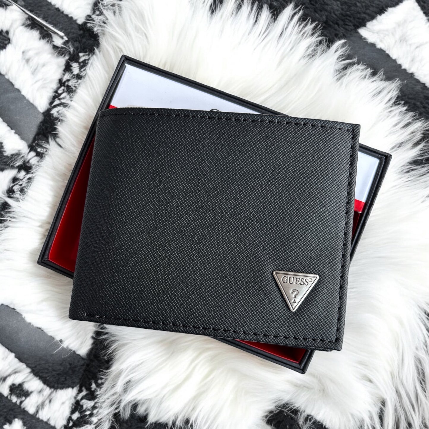 Cartera Guess. Negra con placa plateada en triángulo