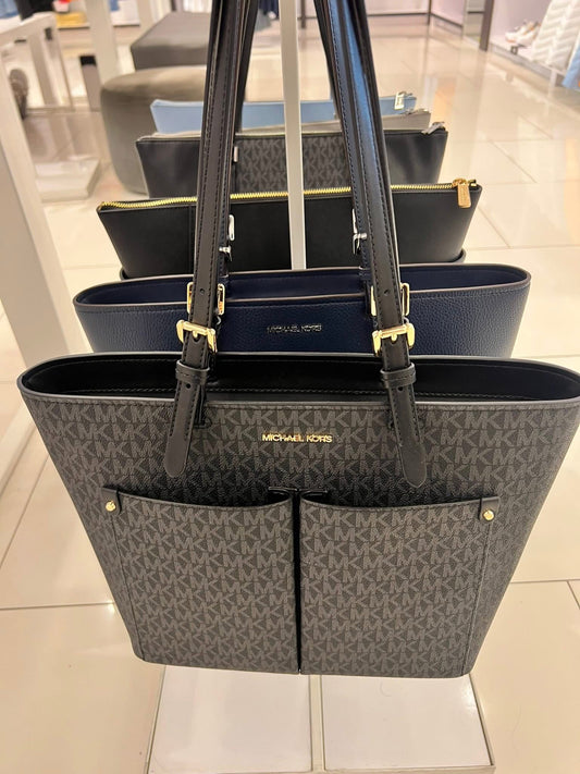 Tote Michael k negra con monogram y bolsas en frente