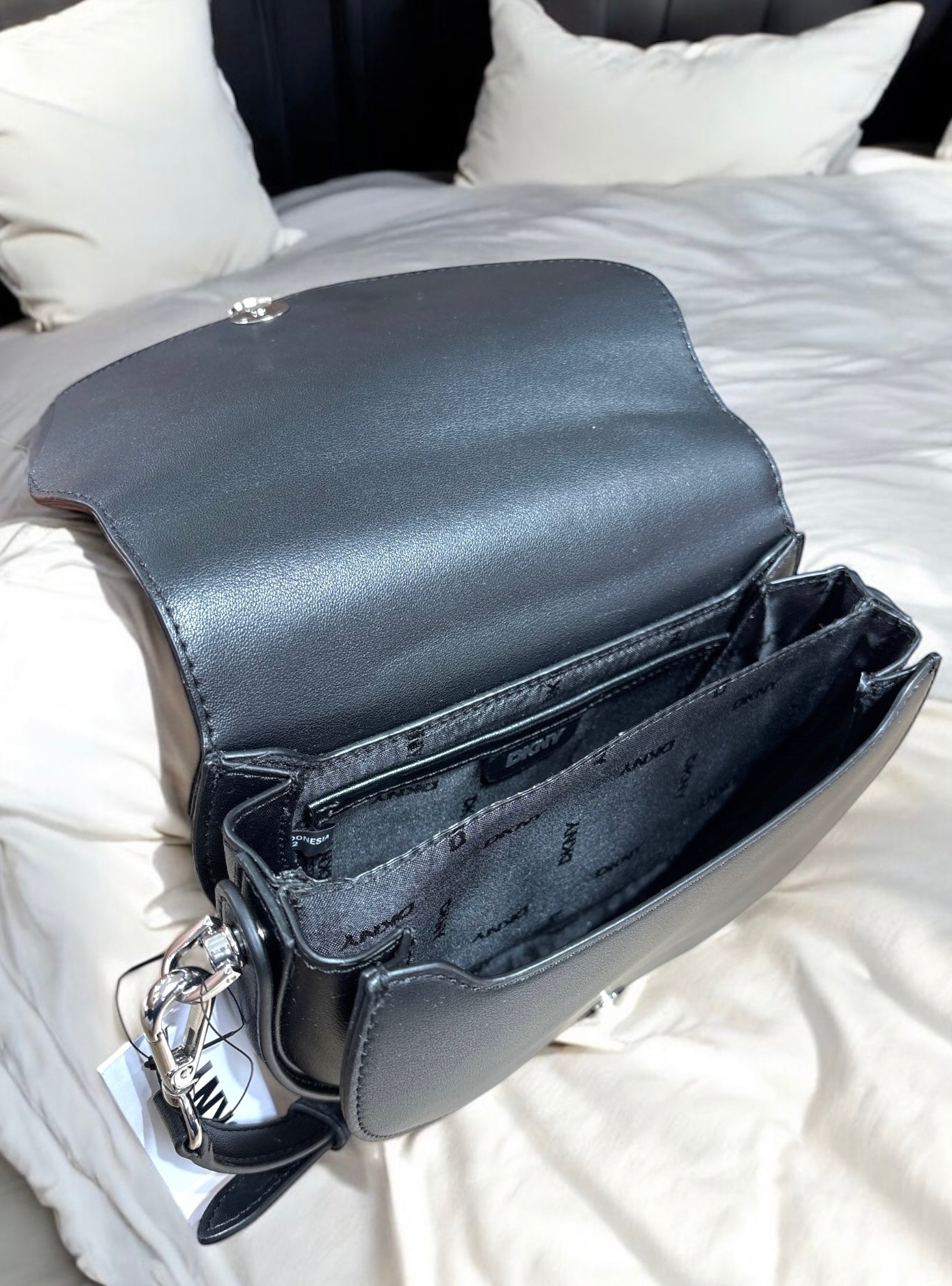 Crossbody Sana Flap DKNY negra, placa plateada