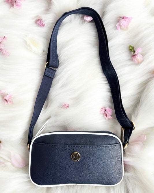 Crossbody Tommy H azul marino con raya blanca y placa dorada redonda