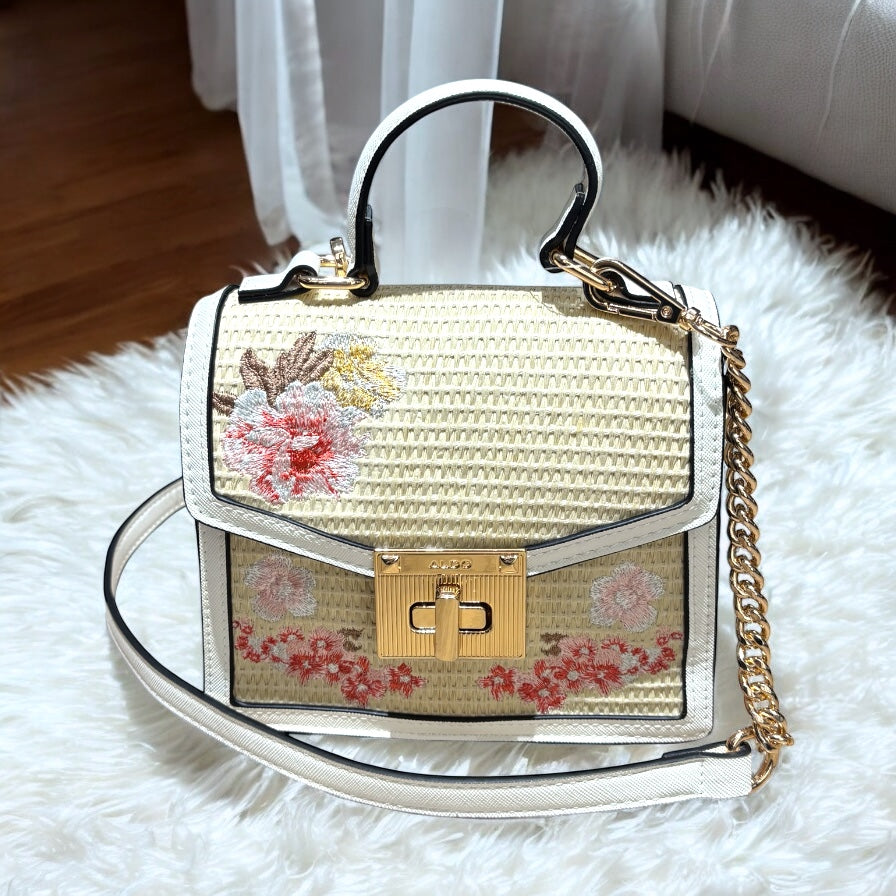 Crossbody Aldo pequeña yute/crema con flores, strap con cadena y placa dorada