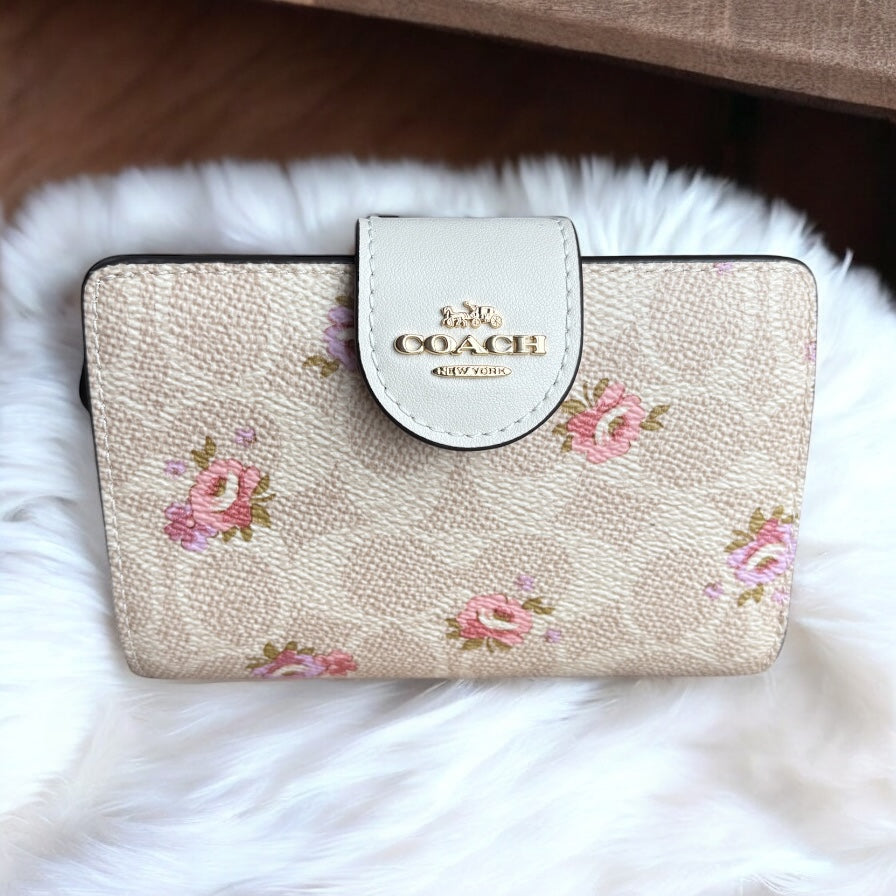 Cartera Coach beige con flores, monogram, broche y cierre