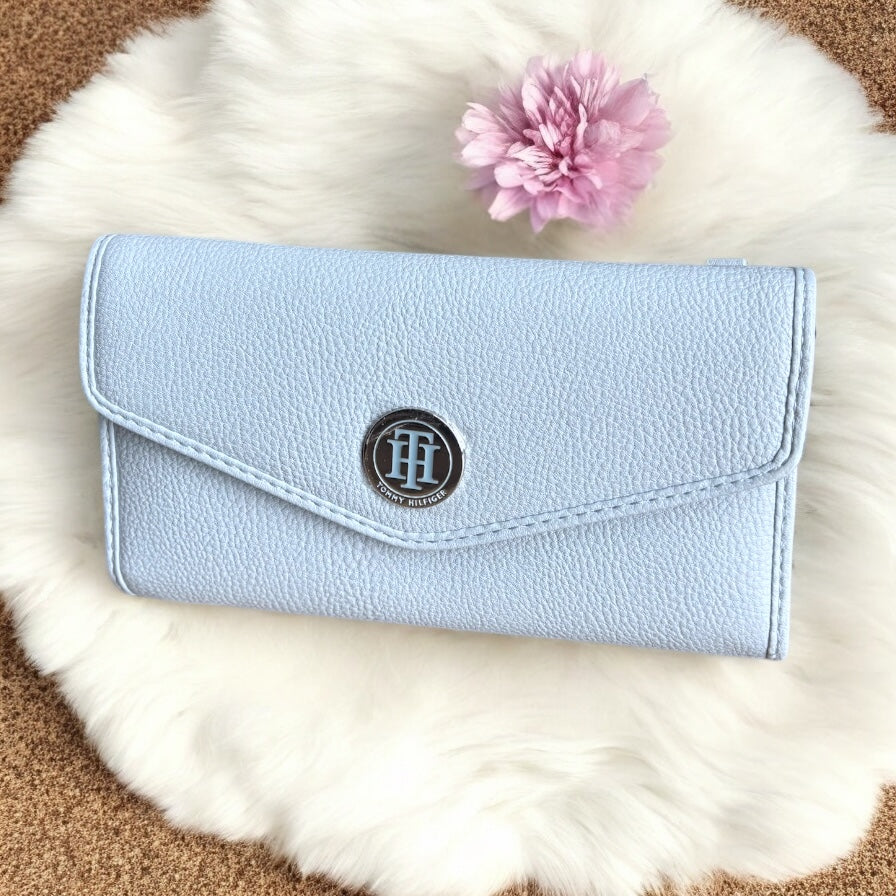 Cartera Tommy H azul claro con textura, cierre atrás y placa plateada