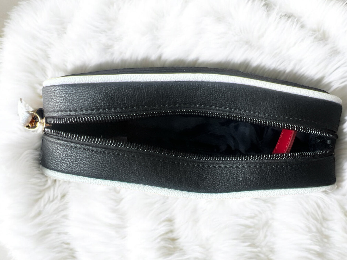 Crossbody Tommy H negra con contorno blanco y placa dorada redonda