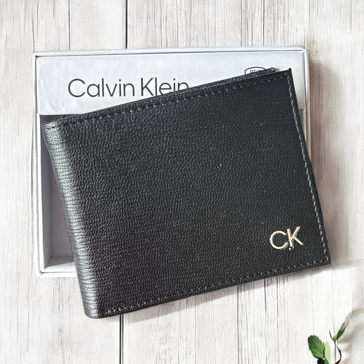Cartera Calvin k negra con placa plateada en lado inferior derecho