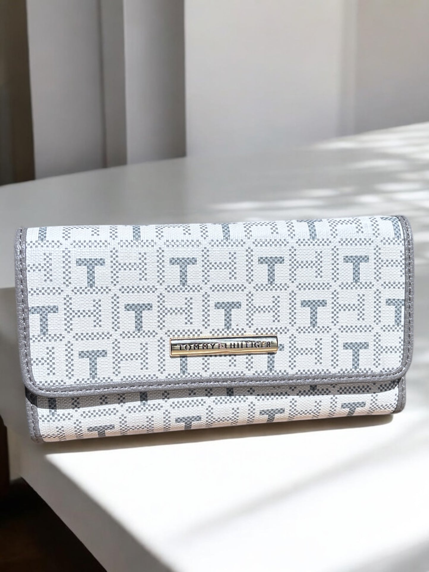 Cartera Tommy H crema con monogram gris y placa dorada
