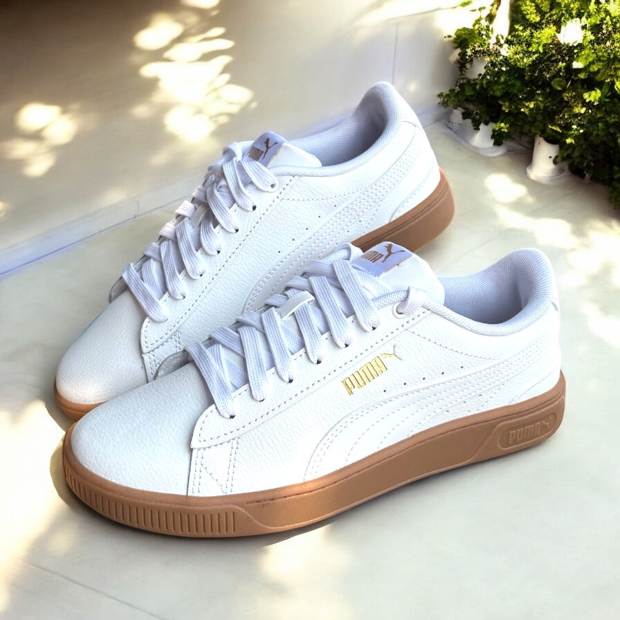 Tenis Puma crema detalle de logo dorado y suela camel