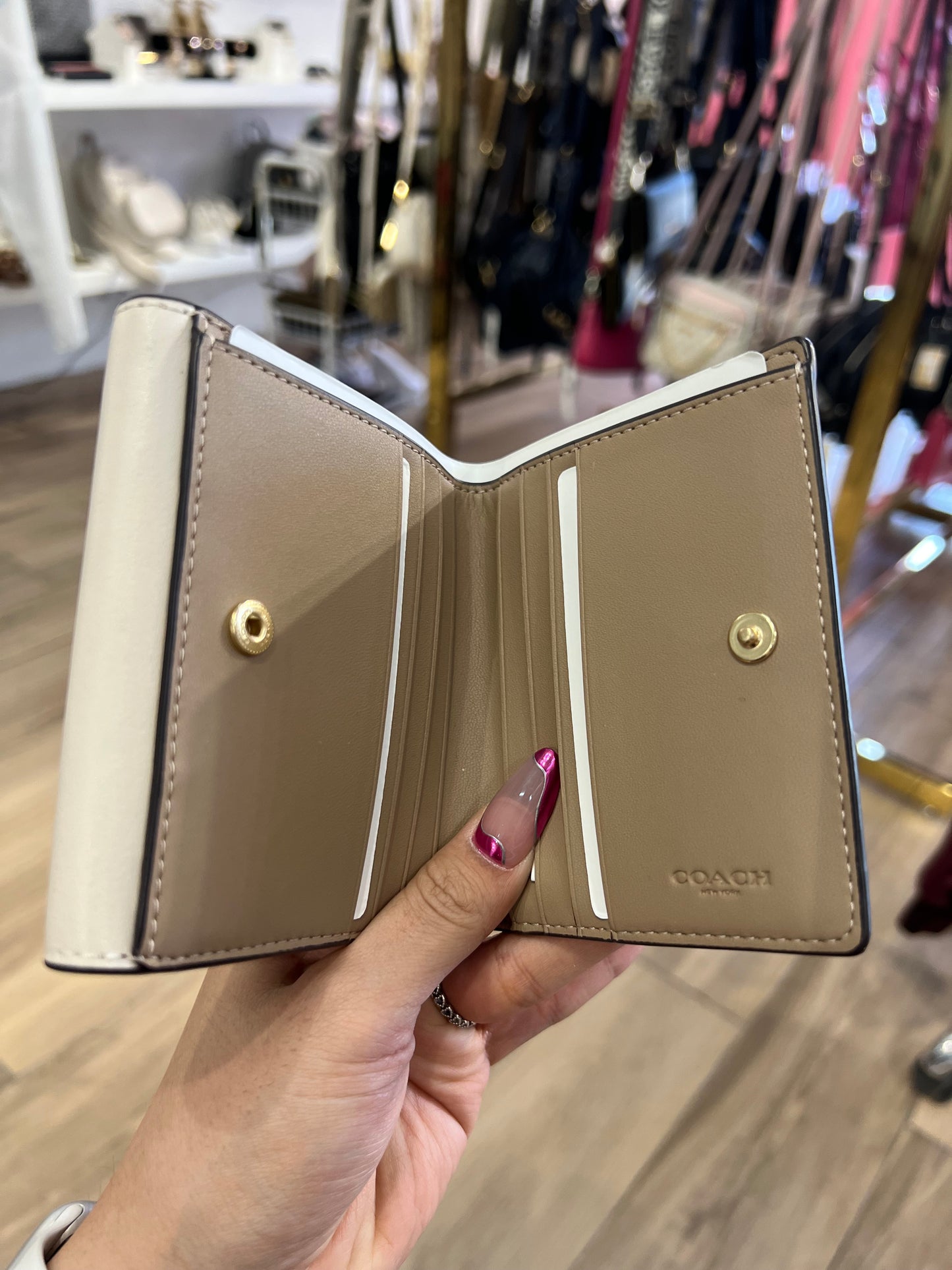 Cartera Coach crema/beige con placa dorada