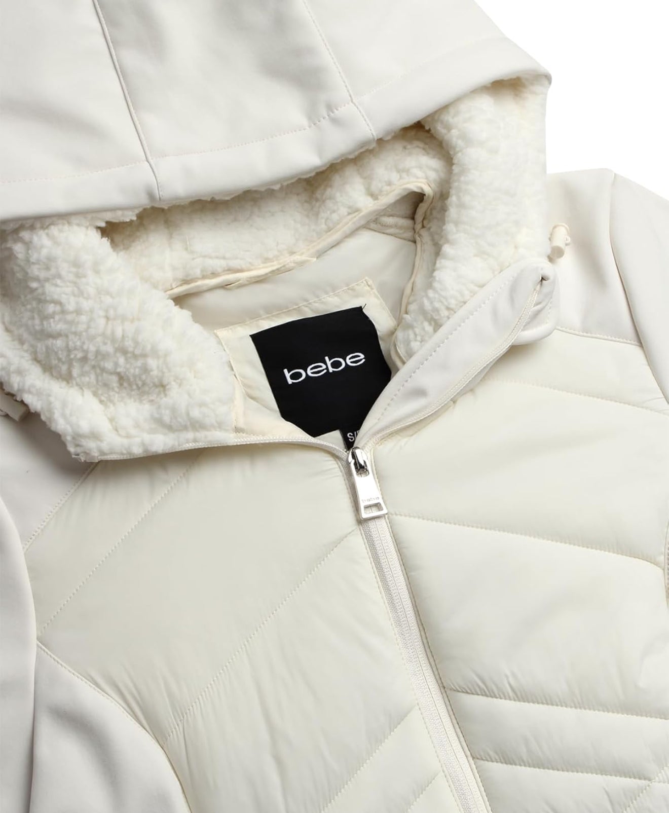 Chamarra Bebe crema capitonadalisa, gorrito afelpado y placa negra con brillos