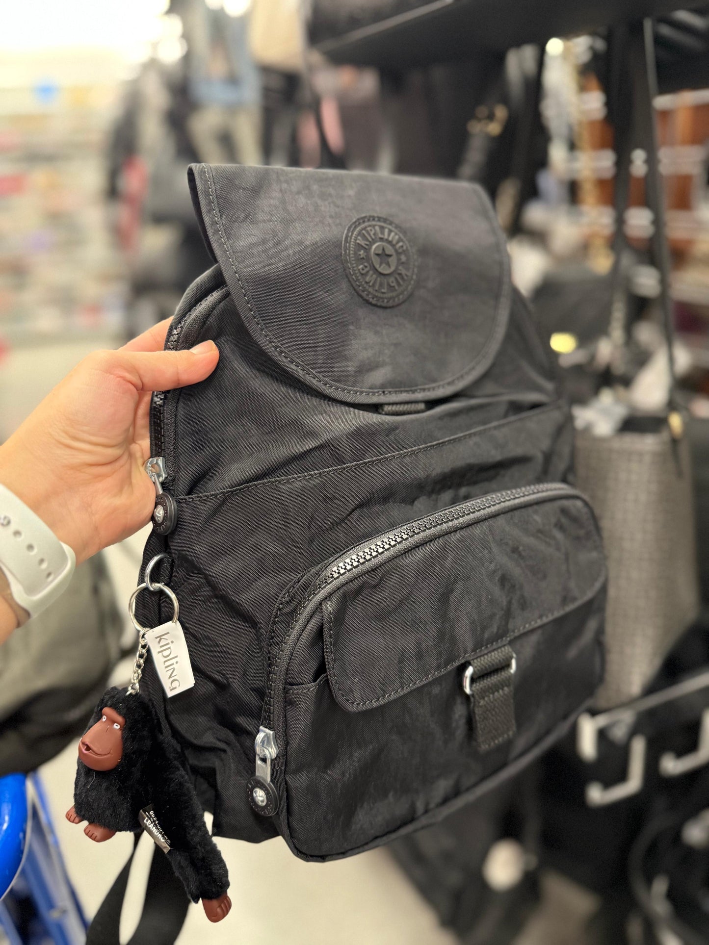 Backpack Kipling negra con changuito y placa dorada