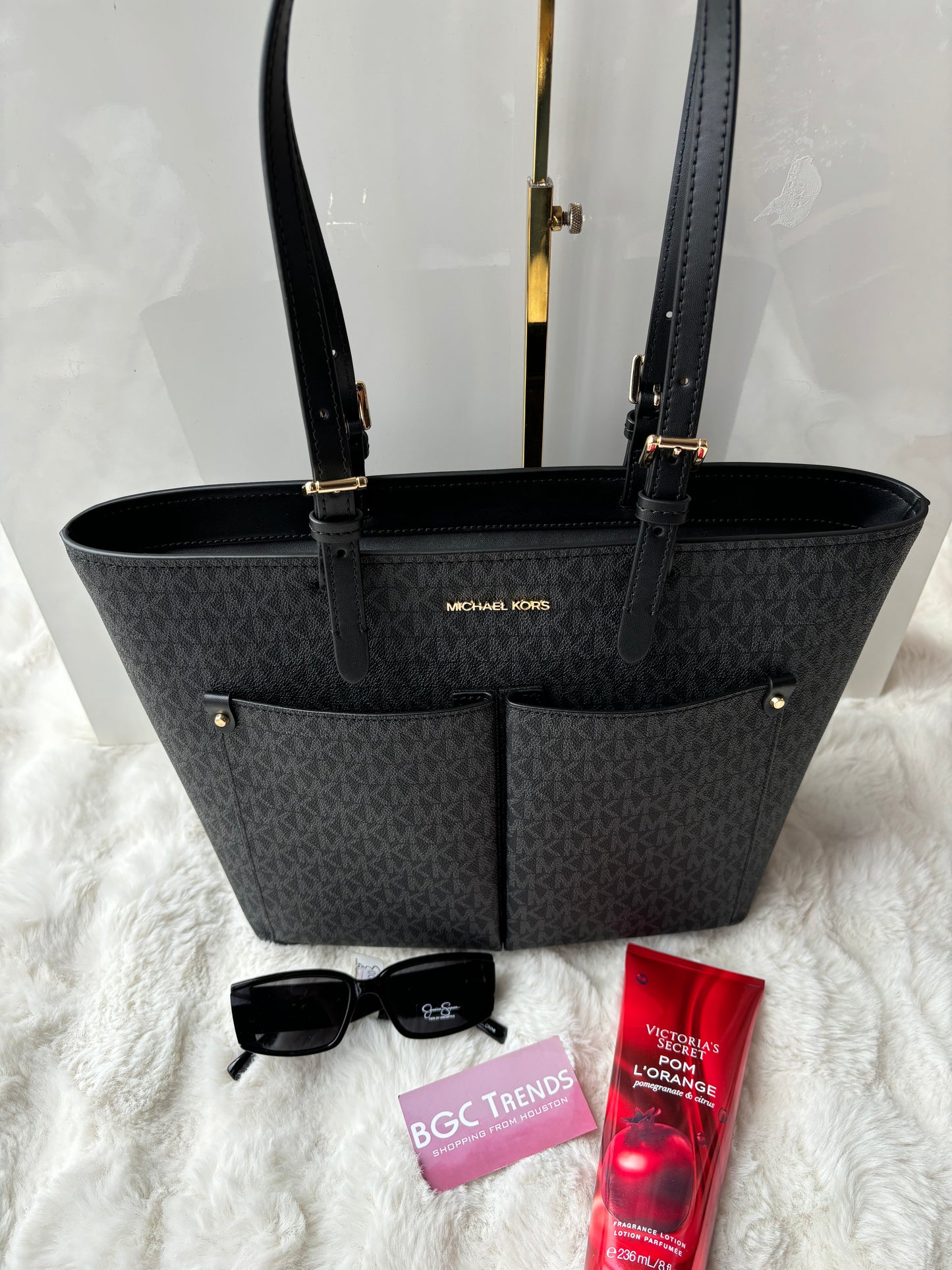 Tote Michael k negra con monogram y bolsas en frente
