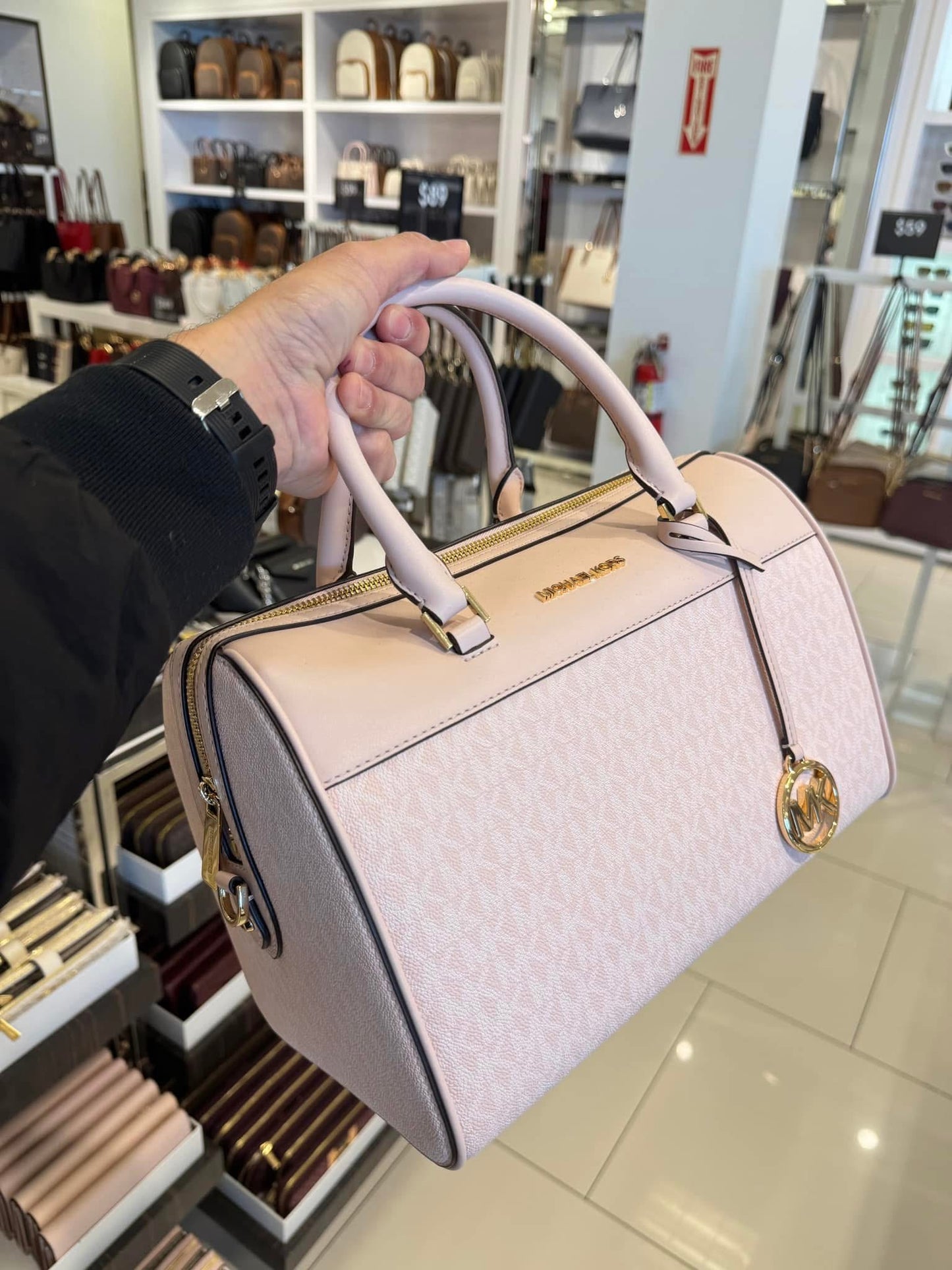 Crossbody Michael K Travel rosa con monogram y detalles dorados