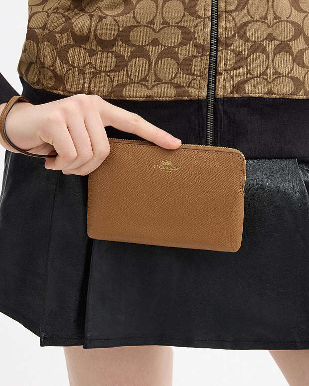 Muñequera Coach camel, strap y logo grabado dorado