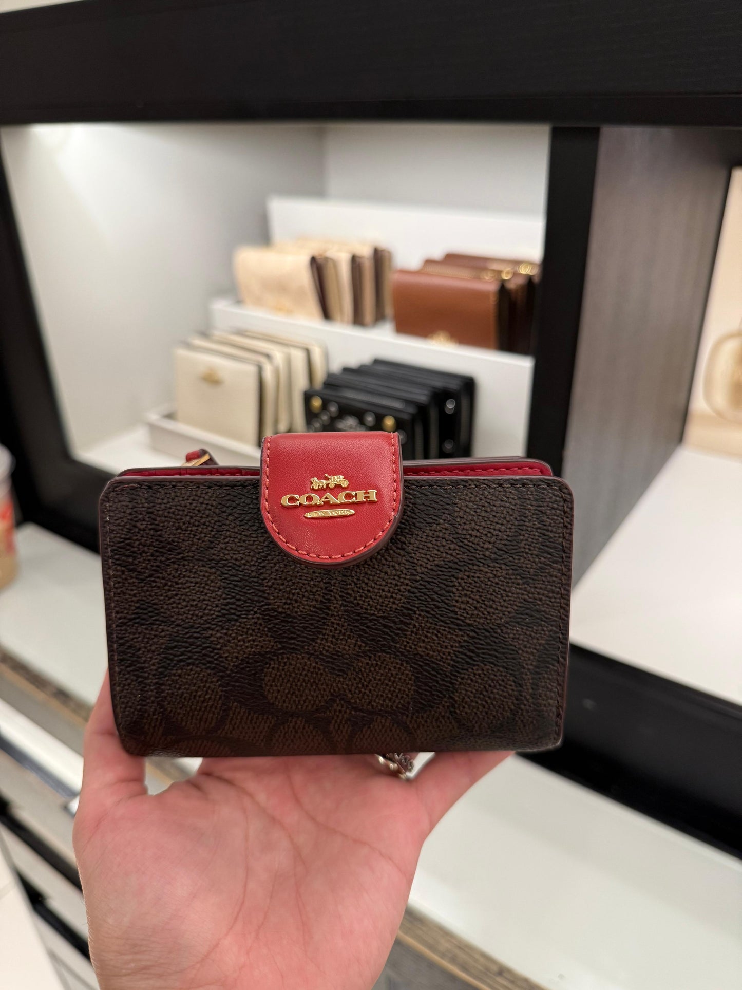 Cartera Coach chocolate/rojo, strap y placa dorada