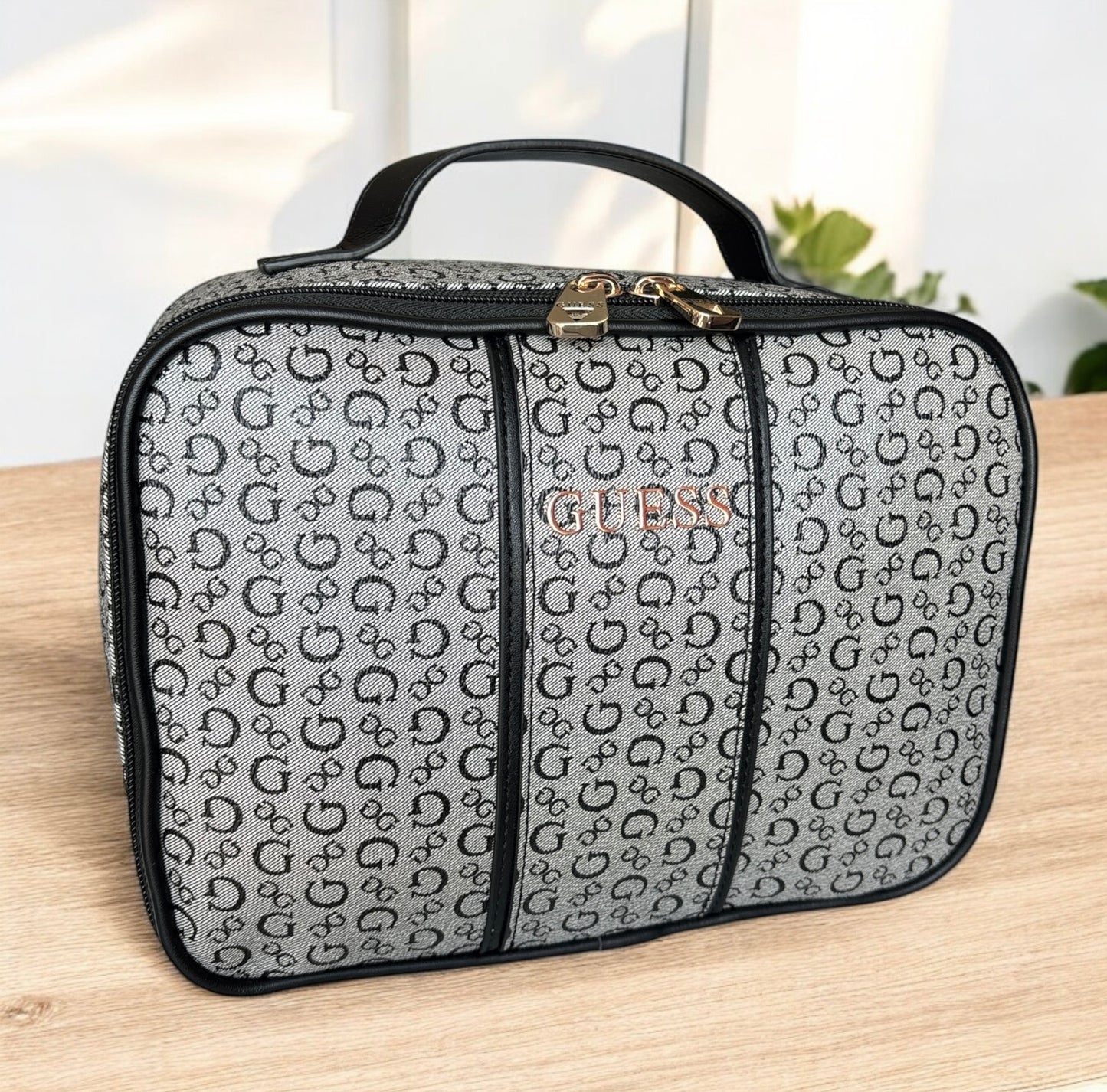 Cosmetiquera Guess gris con monogram negro y placa dorada