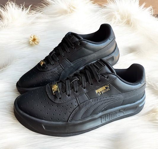 Tenis Puma negros para caballero detalles en dorado y logo en suela