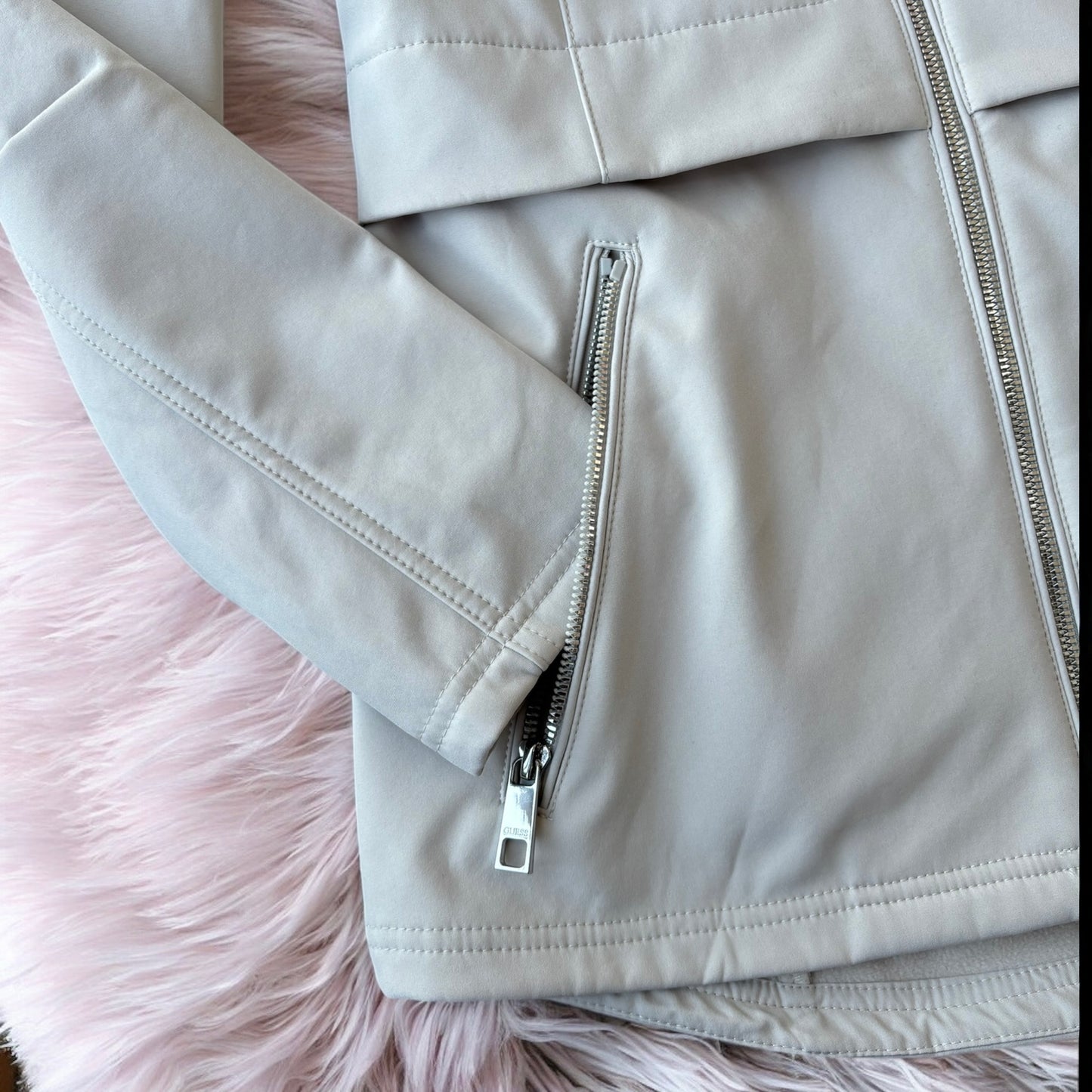Chamarra Guess beige con placa plateada en el brazo