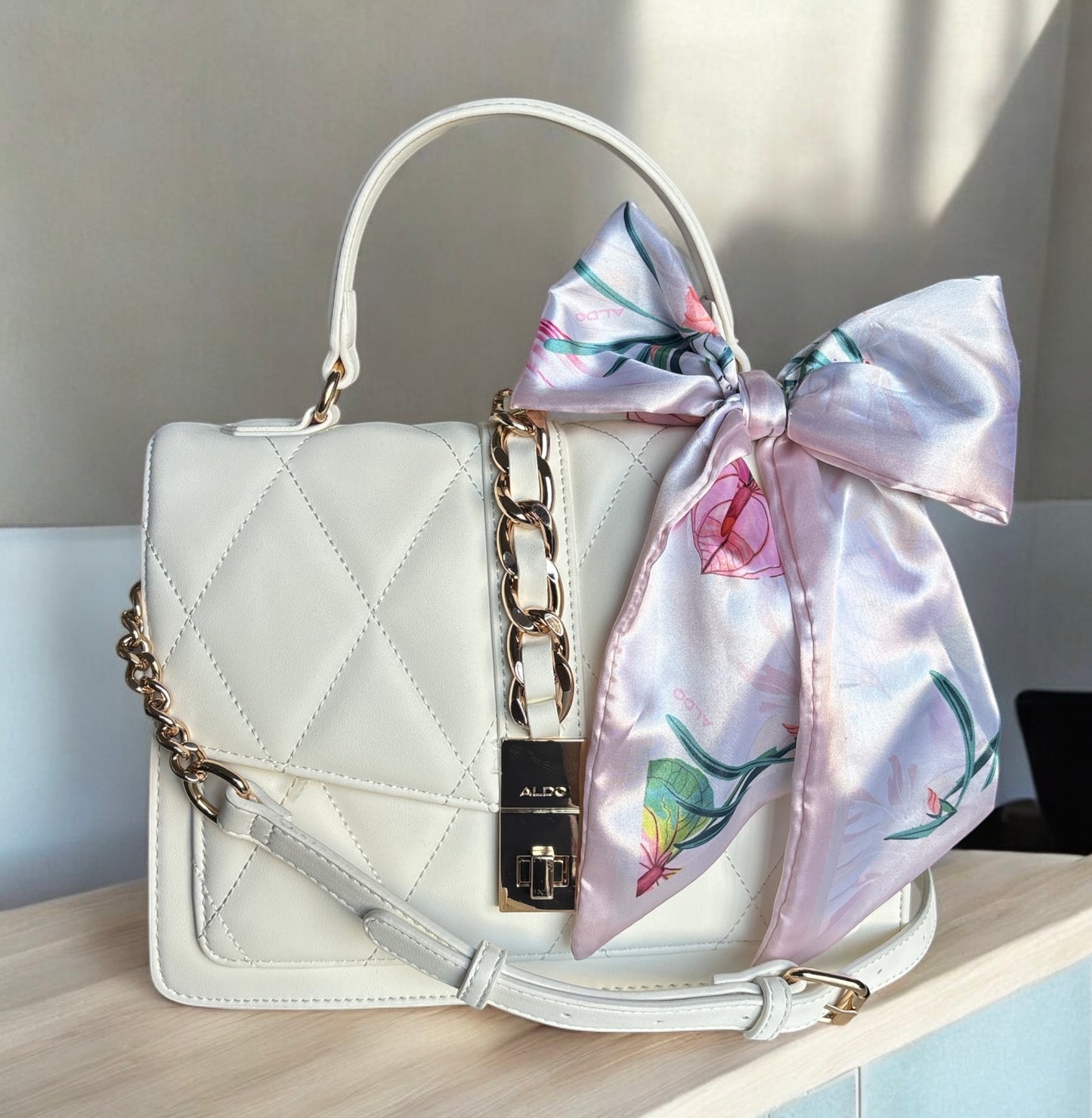 Crossbody Aldo crema con pañuelo y detalles dorados