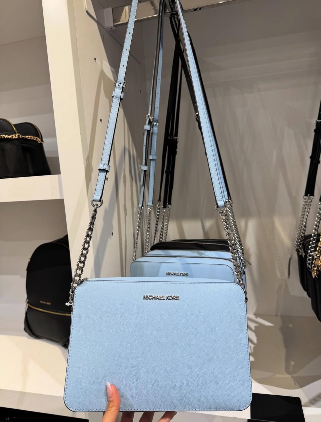Crossbody Michael k azul claro con cadena en strap y placa plateada