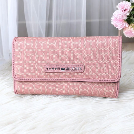 Cartera Tommy H rosa con monogram crema, placa plateada y cierre atrás