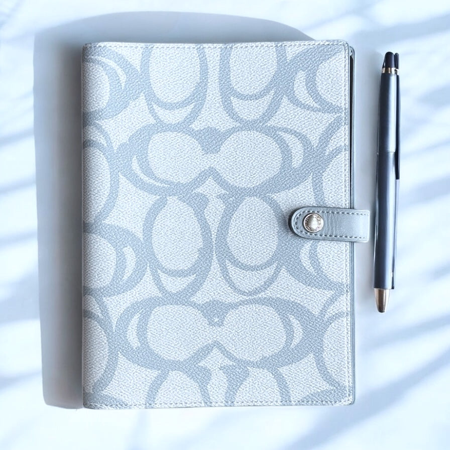 Libreta Coach azul claro con monogram