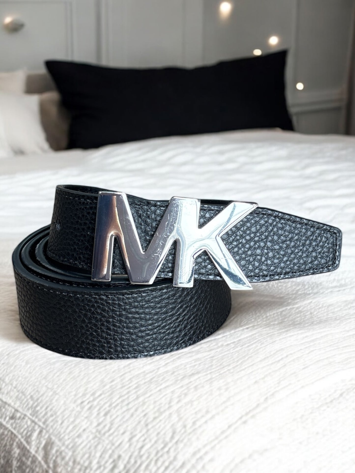 Cinturón Michael K negro con textura, hebilla MK plateada grande