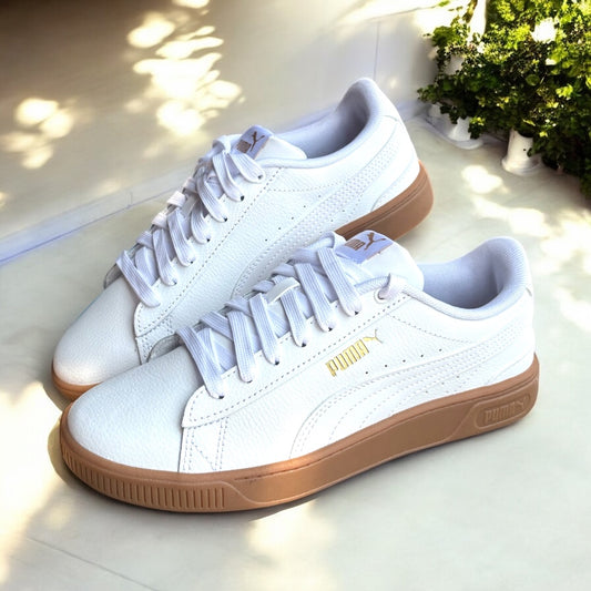Tenis Puma crema detalle de logo dorado y suela camel